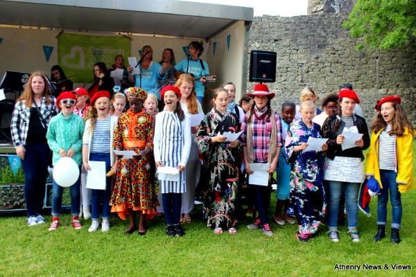 Group of children from diverse cultures pictured at a food festival celebrating multiculturalism.