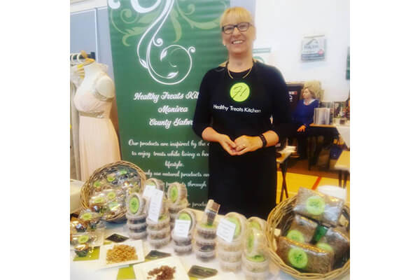 Anita’s Healthy Kitchen standing behind some of her producs